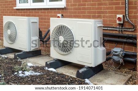 Two air source heat pump units installed on a modern house