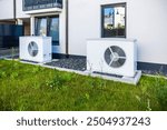 Two air source heat pumps installed outside of new and modern city house, green renewable energy concept of heat pump