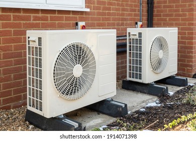 Two air source heat pumps installed on the exterior of a modern house - Shutterstock ID 1914071398