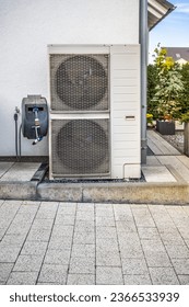 Two air source heat pumps installed outside of modern family house, green renewable energy concept of heat pump - Shutterstock ID 2366533939