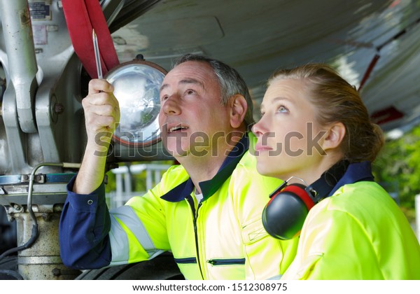 two\
aircraft engineers inspecting plane\
construction