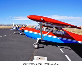 Two Airplanes Parked Outside on an Airport Ramp - Powered by Shutterstock