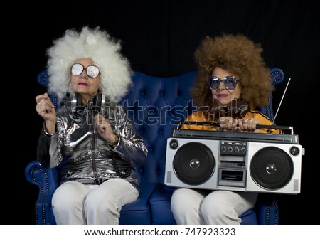 two amazing grandmas partying in a disco setting holding a retro ghettoblaster