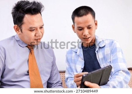 Two Ambitious Men Collaborating on Project With Tablet