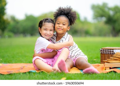 Two American African Little Girl As Friends Hug Each Other In Cheerful Way. Little Girlfriends In Park. Childhood, Family, Love, Friendship And Happiness People Concept