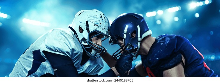 Two American football players in head-to-head position with intense focus at each other standing under bright stadium lights. Concept of professional sport, competition, tournament - Powered by Shutterstock