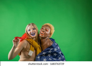 Two American girlfriends international women hold the flag of America covered with it and smile emotionally - Powered by Shutterstock