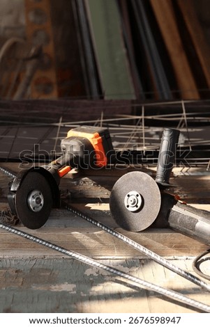 Two angle grinders close-up. Cordless and corded angle grinders, power tools for construction and repair work. Tools close-up. Repair work in the country. Grinders with metal discs