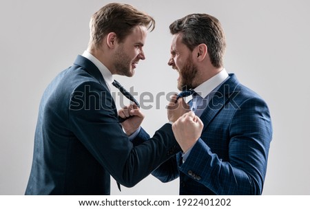 two angry businessmen punching in fight and arguing having struggle for leadership on businessmeeting because of business competition, aggressive negotiations.