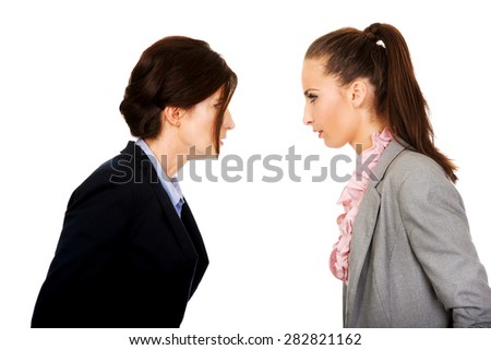 Two angry businesswomans standing face to face.