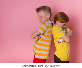 Two Angry Kids Boy And Girl. Frowning Brother And Sister Standing Back To Back. School Children Do Not Talking To Each Other.