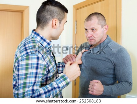 Two angry men looking at each other with clenching fists