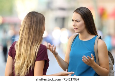 Two Angry Women Friends Talking Seriously On The Street