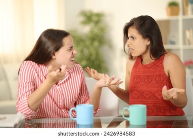 Two angry women at home arguing at coffee break - Powered by Shutterstock