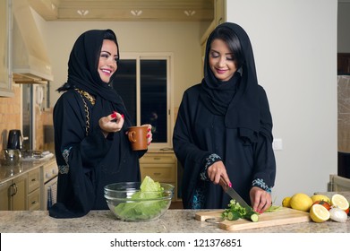 Two Arabian Women Gathering Cooking & Drinking Coffee In Kitchen