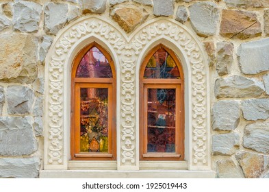 Two arched windows in the stone wall.