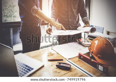 Two Architect man working with compasses and blueprints for architectural plan,engineer sketching a construction project concept.