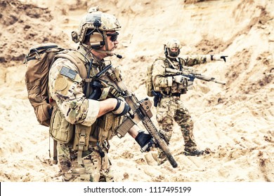 Two Armed US Army Commandos Or Military Scouts Equipped With Radio Headset Moving Forward In Sands During Enemy Area Reconnaissance. Special Forces Operation, Long Range Surveillance Mission In Desert