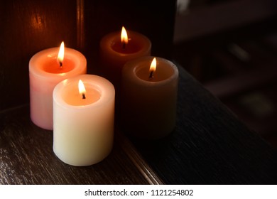 Two aromatic candles are reflected in the dark glass. Romantic magic atmosphere.