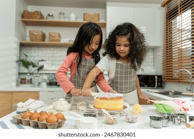 Two Asian adorable children sibling making a cake in kitchen at house. Happy Family, young little kid girls having fun spend leisure time together using ingredient bake bakery. Activity relationship. - Powered by Shutterstock