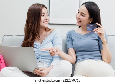 Two Asian Beauty People Are Using A Credit Card To Make Purchases Using A Laptop Via The Internet. With A Happy Smiling Face, Being A New Normal Online Business In The Shopping Experience From Home.