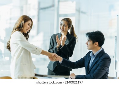 Two Asian Business Partners Successful Handshake Together In Front Of Group Teamwork Casual Business Clapping Hands Winning Success Agreement In Modern Office.Partnership Approval And Teamwork