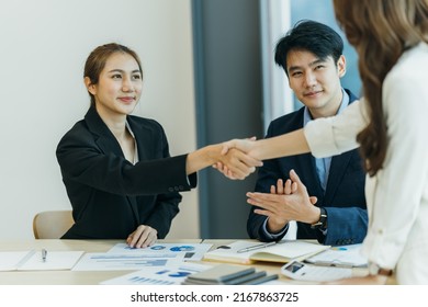 Two Asian Business Partners Successful Handshake Together In Front Of Group Teamwork Casual Business Clapping Hands Winning Success Agreement In Modern Office.Partnership Approval And Teamwork