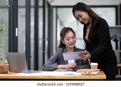 Two Asian Business Woman Work Together To Get The Job Done At The Office.
