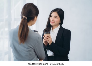 Two Asian Business Woman Work Together To Get The Job Done At The Office.