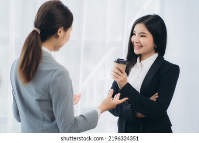 Two Asian Business Woman Work Together To Get The Job Done At The Office.