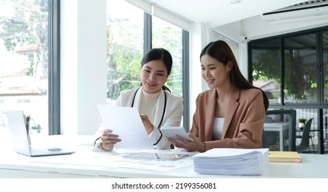 Two Asian Business Woman Work Together To Get The Job Done At The Office.
