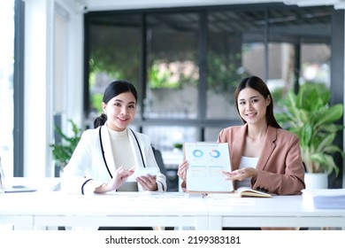 Two Asian Business Woman Work Together To Get The Job Done At The Office.
