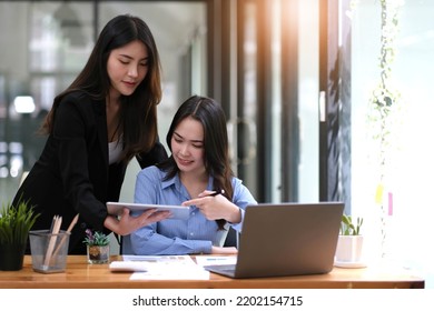 Two Asian Business Woman Work Together To Get The Job Done At The Office.
