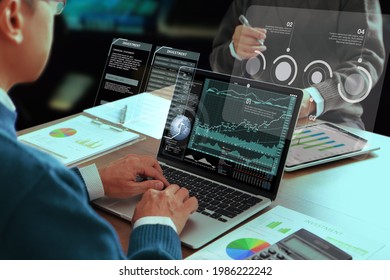 Two Asian Businessmen Or Analysts In A Modern Office Reviewing Financial Statements For Business Performance And Analysing On A Return On Investment, ROI.