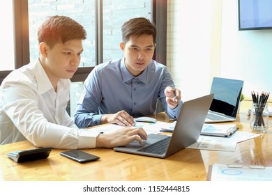 Two Asian Businessmen Working Together In Business Meeting Room In Office