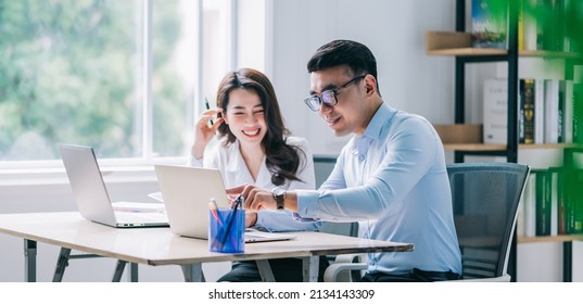 Two Asian businesspeople working at office - Shutterstock ID 2134143309