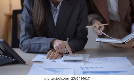 Two Asian businesswomen with friends and discussed their ideas at a meeting, Businesswoman talking with financial statement report together  at the office. - Shutterstock ID 2365414617