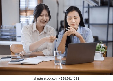 Two Asian businesswomen with friends and discussed their ideas at a meeting, Businesswoman talking with financial statement report together  at the office. - Shutterstock ID 2365414631