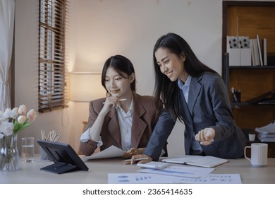 Two Asian businesswomen with friends and discussed their ideas at a meeting, Businesswoman talking with financial statement report together  at the office. - Shutterstock ID 2365414635