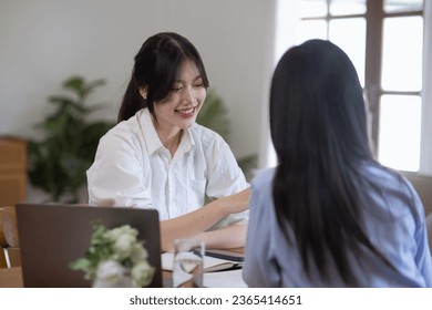 Two Asian businesswomen with friends and discussed their ideas at a meeting, Businesswoman talking with financial statement report together  at the office. - Shutterstock ID 2365414651