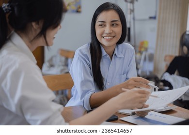 Two Asian businesswomen with friends and discussed their ideas at a meeting, Businesswoman talking with financial statement report together  at the office. - Shutterstock ID 2365414657