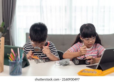 Two Asian Children Having Fun Learning Coding Together, Learning Remotely At Home, STEM Science, Homeschooling Education, Fun Social Distancing, Isolation, New Normal Concept