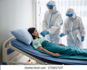 Two asian doctor wear PPE suit with N95 mask and faceshield, treat and use oxygen mask with coronavirus infected patient in negative pressure room. Coronavirus, medical and covid19 concept. - Powered by Shutterstock