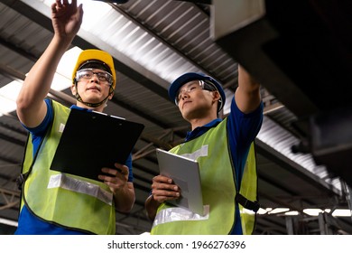 Two Asian engineer male worker maintaining machine at the industry factory. Group of Asian Factory worker check or maintenance CNC machine in industry factory - Powered by Shutterstock