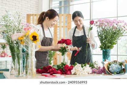 Two Asian female florists cutting and arranging flowers at flower shop. Small business owner. entrepreneur - Powered by Shutterstock