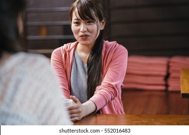 two asian female friends chatting in a traditional Japanese restaurant in Kyoto