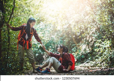 Two Asian Female Hikers Help Each Other At Hiking Trail.