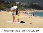 Two asian girls tanning on sea beach in Yalong bay of Hainan island