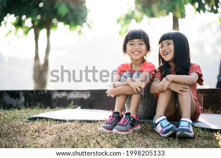 two Asian kid is take a break after exercise in the park in the morning
