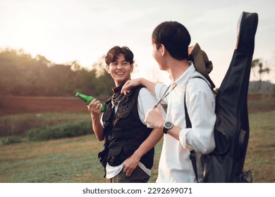 Two asian men close friends travelling together at campgrounds, enjoy camping amomg beautiful sunset time, Camping lifestyle outdoor and relax on summer. - Shutterstock ID 2292699071